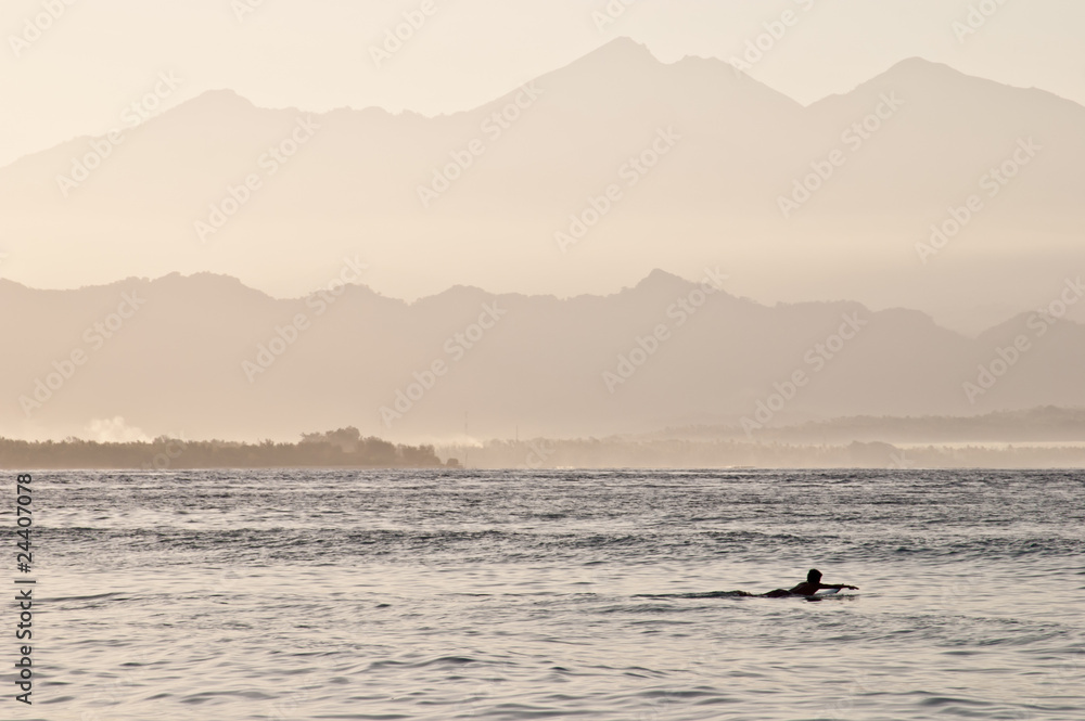 Lonely surfer at dawn, Gili island, Indonesia