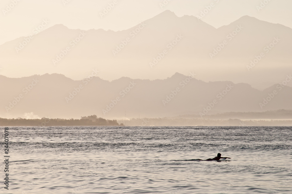 Lonely surfer at dawn, Gili island, Indonesia Lonely surfer at dawn, Gili island, Indonesia