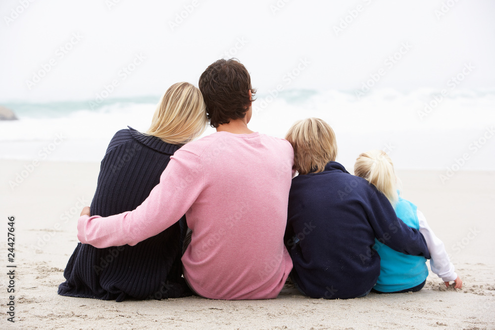 Back View Of Young Family Sitting On Winter Beach Back View Of Young Family Sitting On Winter Beach