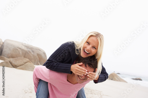 Man Giving Woman Piggyback On Winter Beach