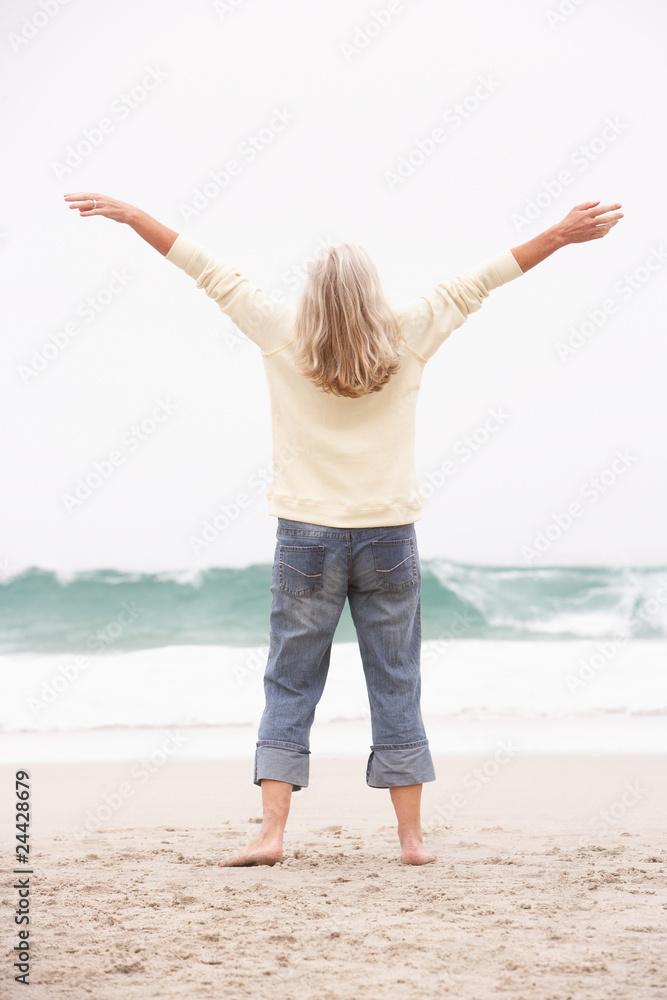 Senior Woman With Arms Outstretched On Winter Beach