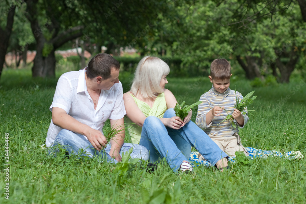 Happy family sitting in park Happy family sitting in park