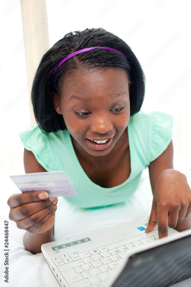 Glowing woman using a laptop sitting on bed Glowing woman using a laptop sitting on bed