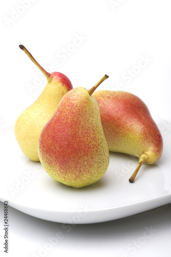 Three pears on a white plate, white background