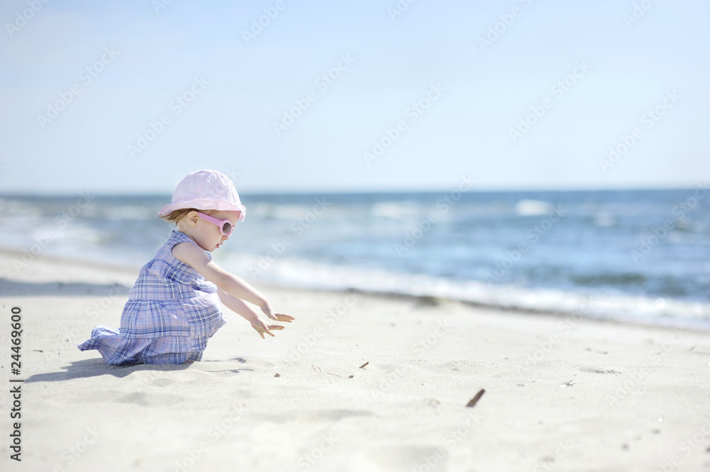Adorable toddler girl on a sand beach