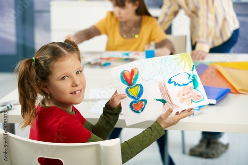 Schoolgirl showing painting in art class