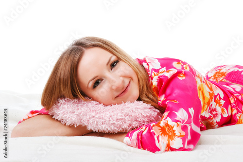 Sweet young girl in pink pajamas on bed