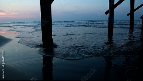 beautiful beach vista from under pier at daybreak