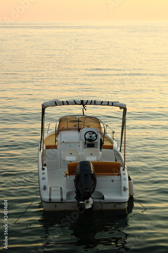 backside of motorized boat with sunset