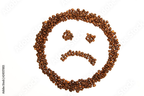 ein trauriger smiley aus kaffeebohnen geformt