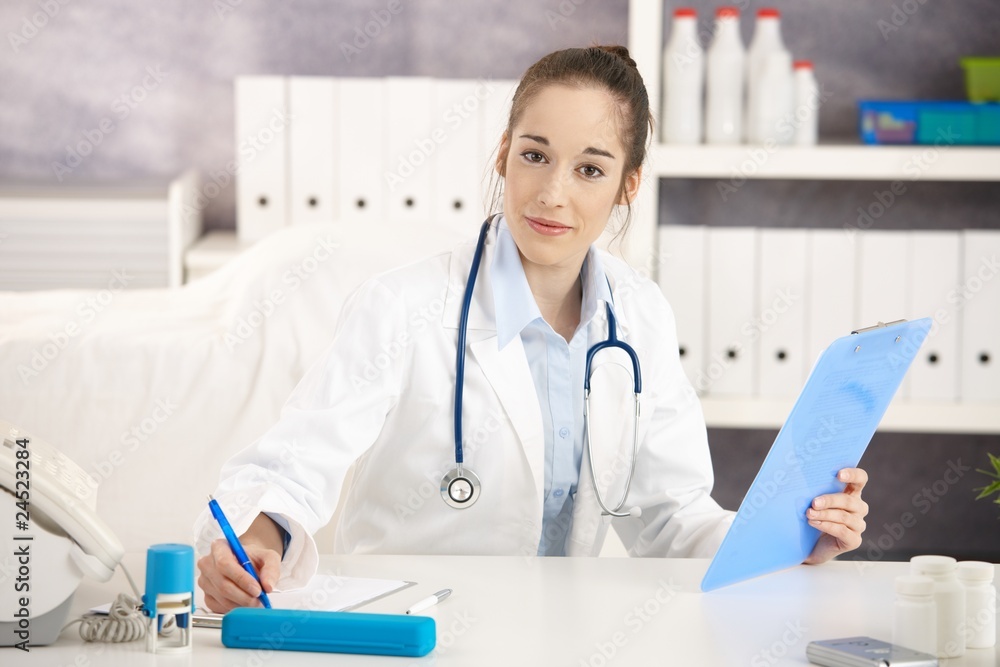 Young female doctor working at desk Young female doctor working at desk