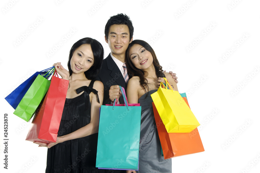 three happy friends with shopping bags standing in the studio three happy friends with shopping bags standing in the studio