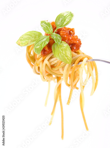 Spaghetti with sauce bolognese hanging on a fork with basil