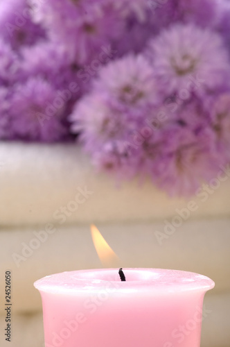 Spa candles and pink flower on towel