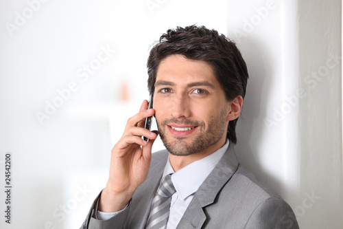 Homme d'affaires souriant au téléphone portable