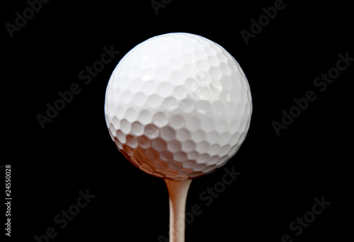 a golf ball on a tee isolated on black