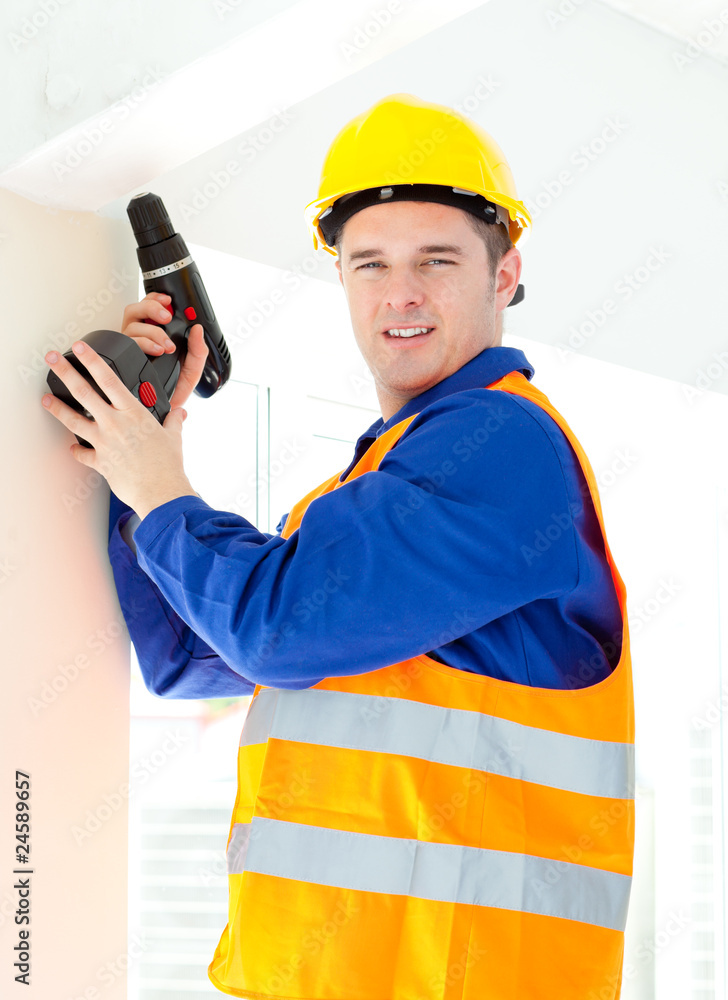 Attractive young worker holding a tool standing on a ladder Attractive young worker holding a tool standing on a ladder