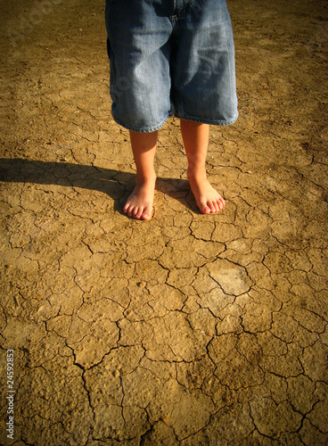 Little boy standing in desert