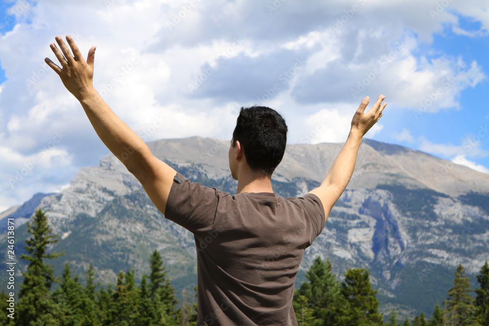 Man standing in nature with arms lifted up Man standing in nature with arms lifted up