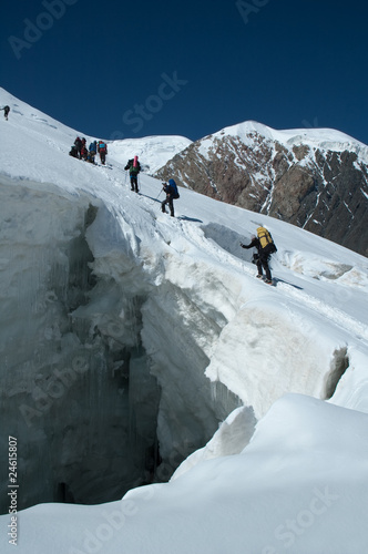 Mountaineers crossing huge crevasse at 4600m on Lenin peak