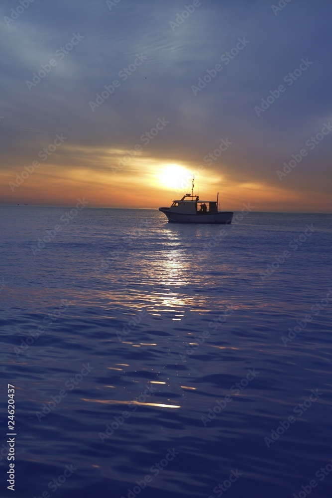sunset sunrise with fishing boat in horizon