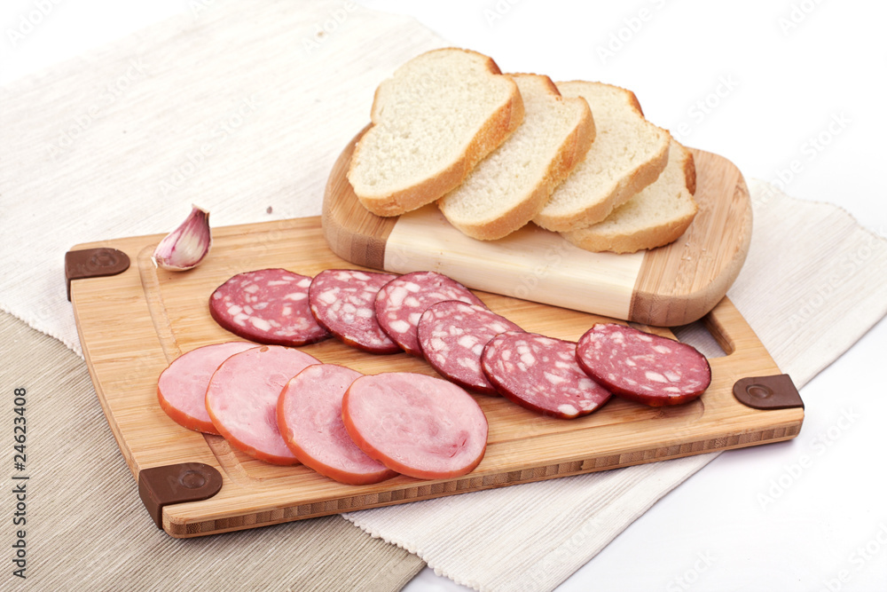 salami slicing next to bread and garlic salami slicing next to bread and garlic