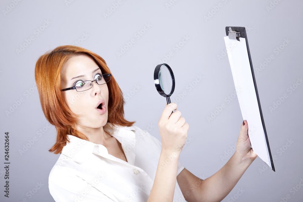 Young businesswomen with white plan board and loupe Young businesswomen with white plan board and loupe