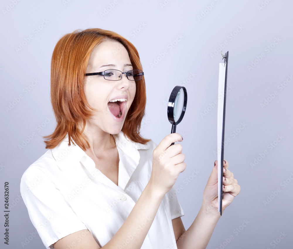 Young businesswomen with white plan board and loupe Young businesswomen with white plan board and loupe