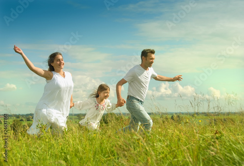 Happy family running on a meadow