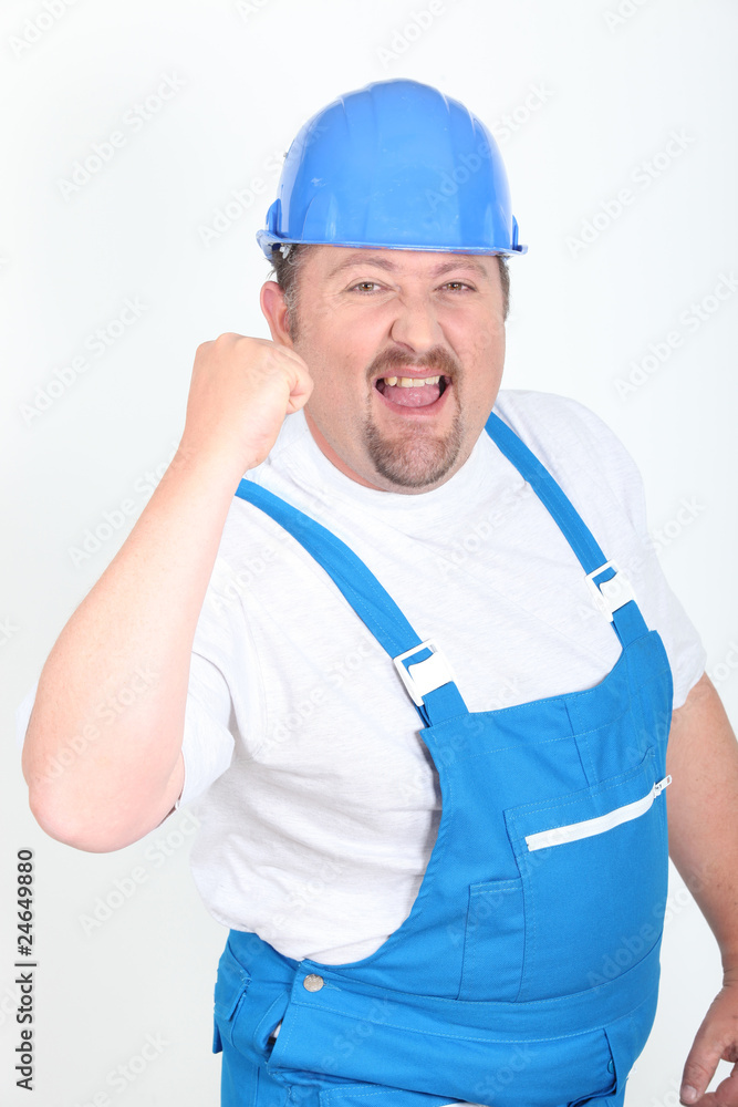 Portrait d'un ouvrier le poing levé sur fond blanc