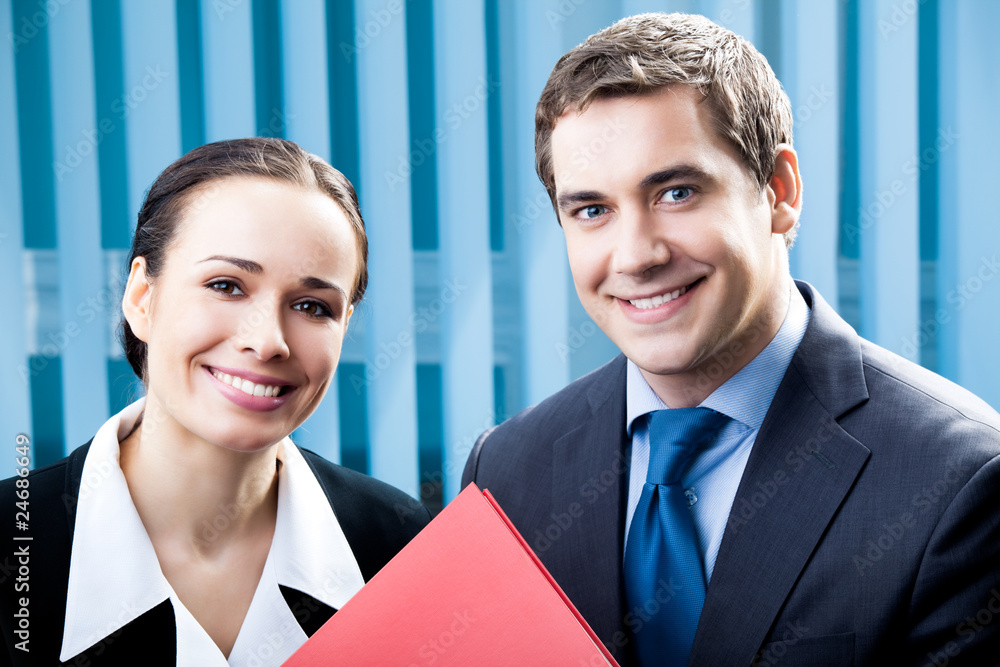 Two happy businesspeople with folder at office Two happy businesspeople with folder at office