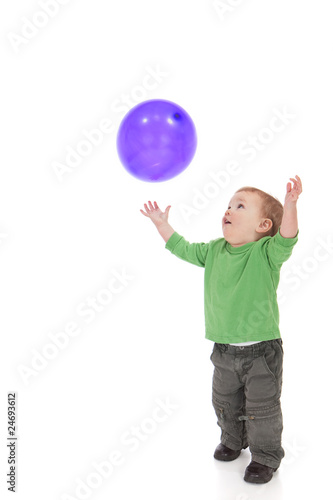 Toddler playing with purple balloon