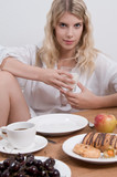 Junge blonde Frau am Frühstückstisch