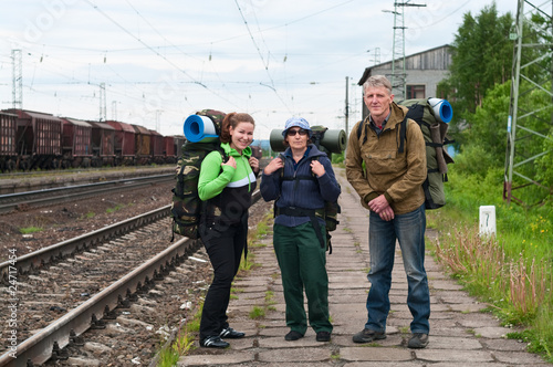 Group of travelers backpackers on railway station waiting train