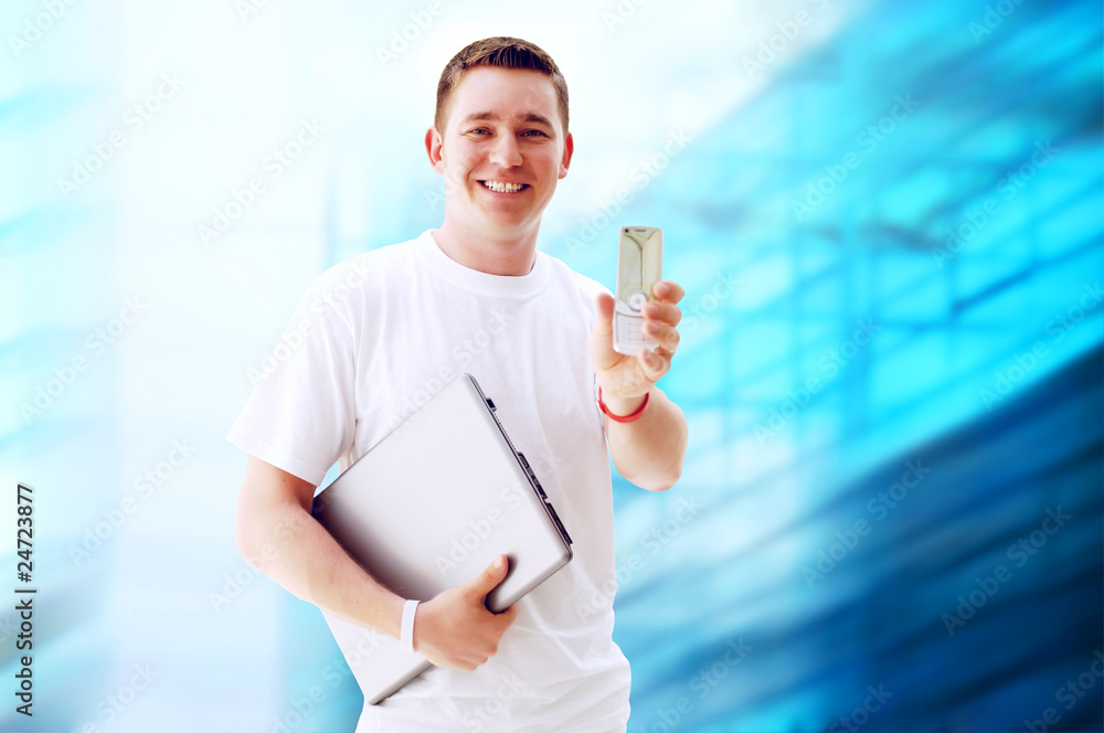 Young happy man or student with laptop and phone on the business Young happy man or student with laptop and phone on the business