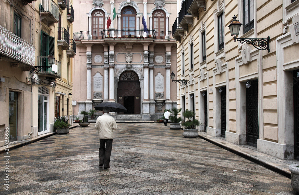 Sicilia - rainy old town in Trapani, anonymous umbrella man