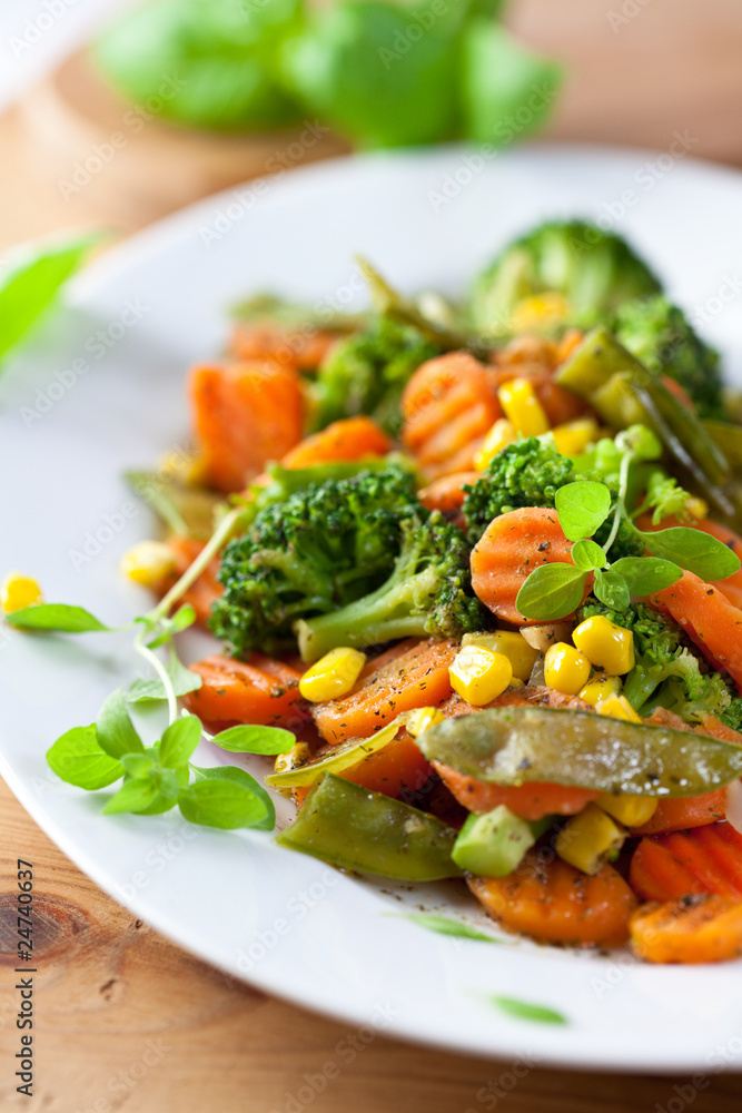 Roasted vegetables with fresh herbs on kitchen table Roasted vegetables with fresh herbs on kitchen table