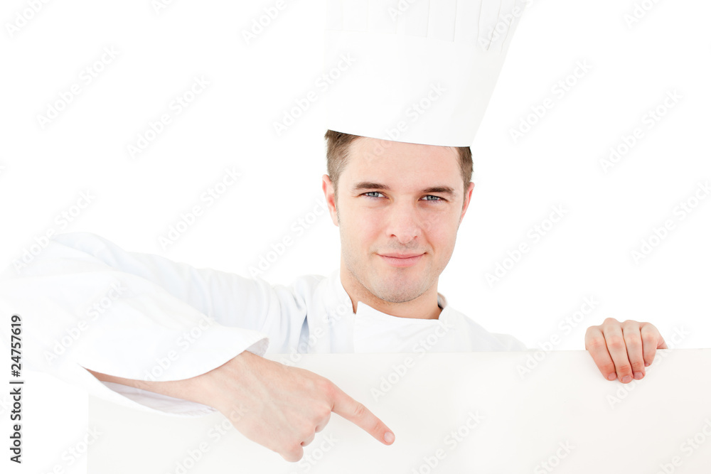 Self-assured caucasian male cook holding a placard showing on it Self-assured caucasian male cook holding a placard showing on it