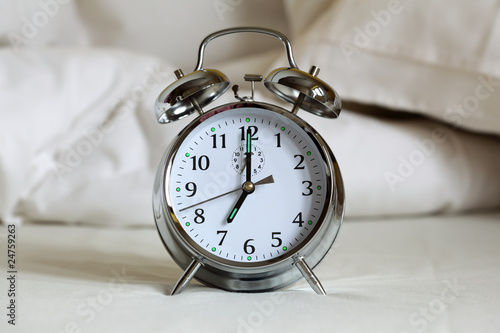 Alarm clock on bed sheets