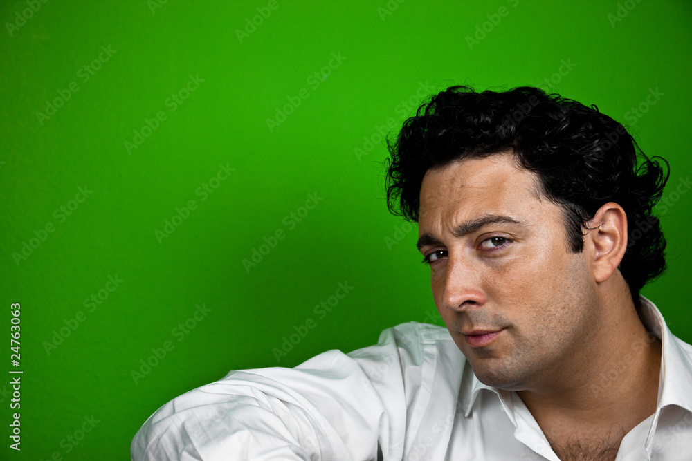 Hombre chulo mirando a camara de perfil sobre fondo verde Hombre chulo mirando a camara de perfil sobre fondo verde