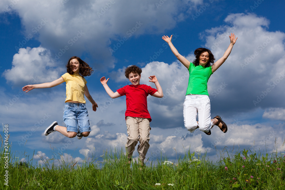 Active family - mother and kids jumping on green meadow Active family - mother and kids jumping on green meadow