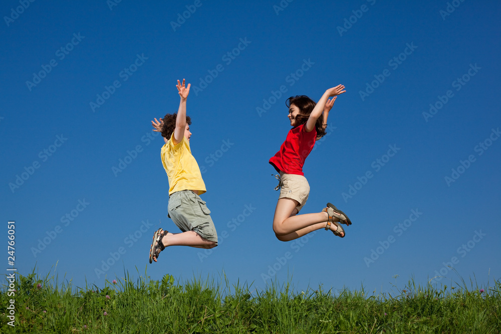 Girl and boy jumping, running against blue sky Girl and boy jumping, running against blue sky