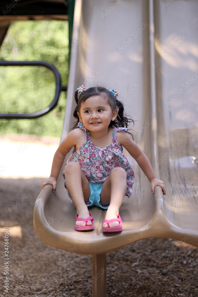 Little Girl at the End of a Slide Stock Photo