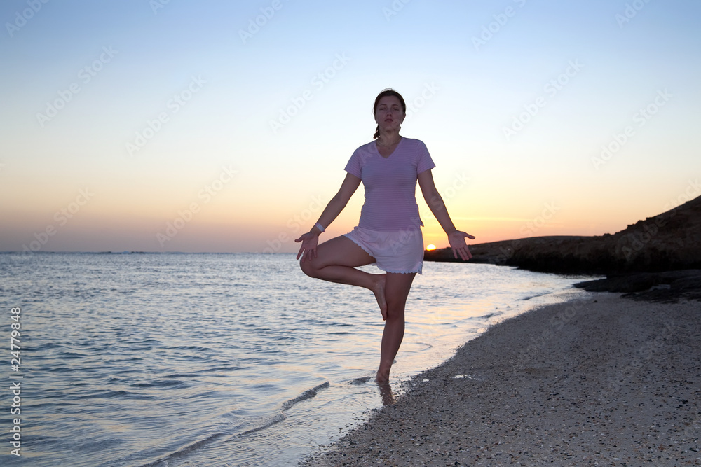 girl doing yoga against sunset