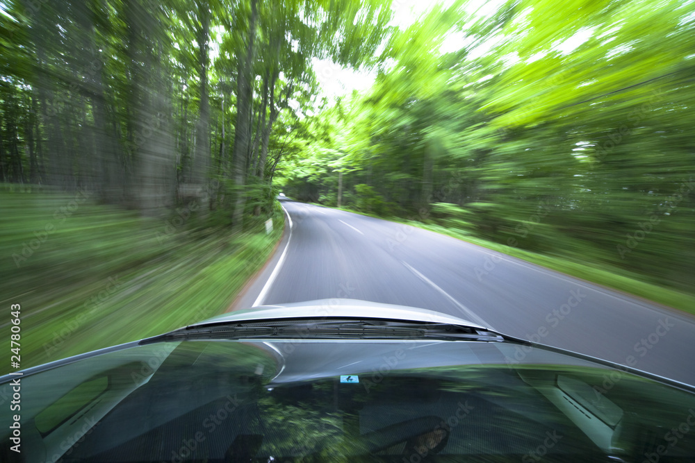 Obraz premium car driving fast into forest