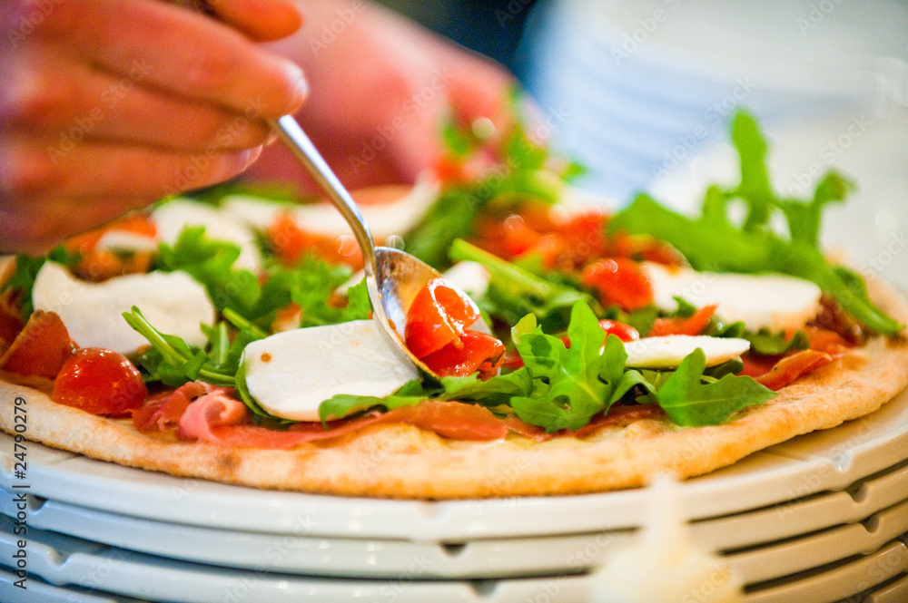 preparing pizza in a kitchen and adding ingredients preparing pizza in a kitchen and adding ingredients