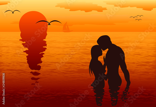 Lovers in the sea at sunset