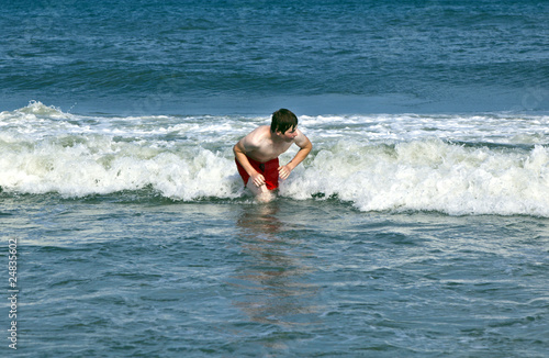 young boy is body surfing in the waves