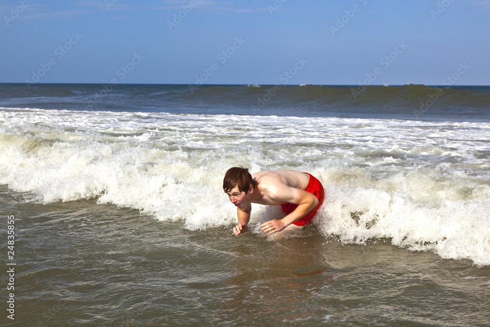 young boy is body surfing in the waves young boy is body surfing in the waves