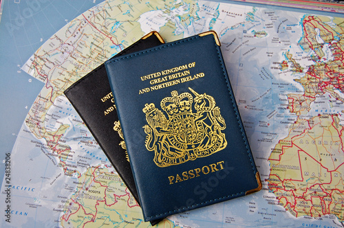 Obraz na płótnie Two British passports overlapping on a map of the world implying travel around t